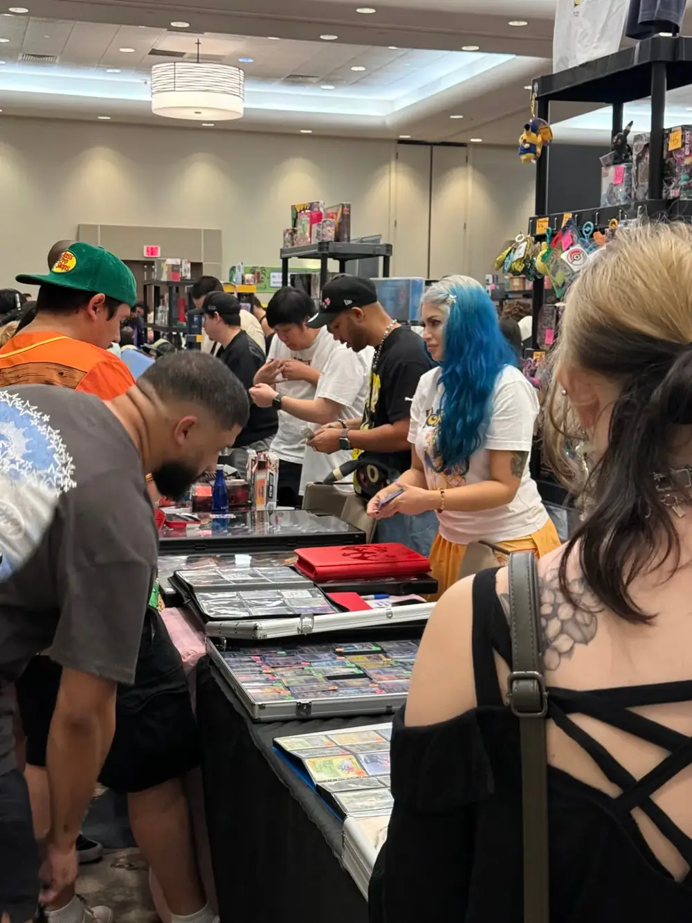 Packed dealer tables at The Cactus TCG Show Collectors crowded around dealer tables trading Pokémon and One Piece singles at The Cactus TCG Show card show in Arizona